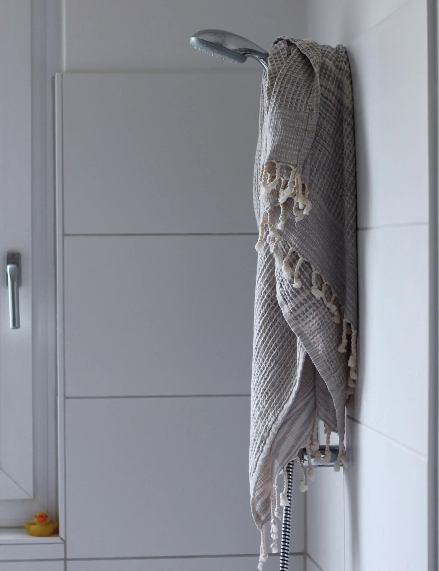Gray waffle weave hammam towel hanging in a modern bathroom