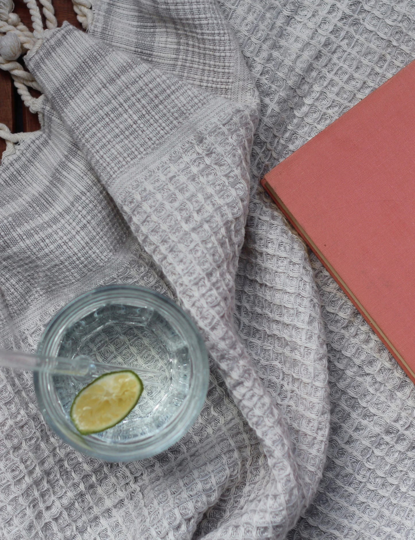 Gray waffle weave hammam towel with a beverage and a book nearby.